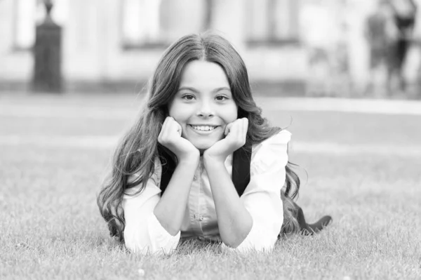 Marzę o przyszłości. Szczęśliwa dziewczyna zrelaksować się na zielonej trawie. Małe dziecko ze słodkim uśmiechem. Przyszłe pokolenie. Przyszłość edukacji. Edukacja daje wiedzę i lepszą przyszłość — Zdjęcie stockowe