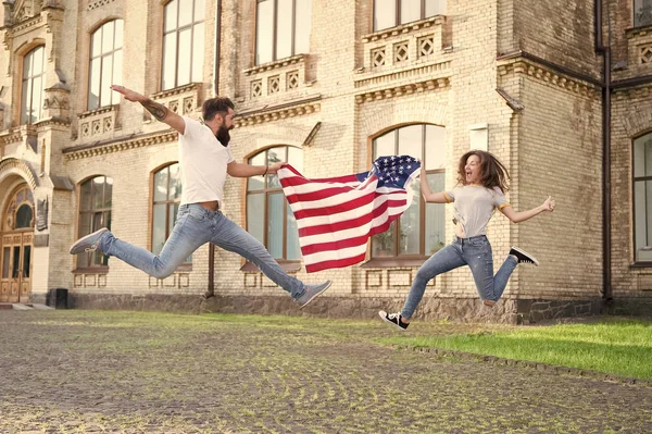 Celebriamo la nostra libertà il giorno dell'indipendenza. Uomo barbuto e donna sexy che salta con bandiera americana il giorno dell'indipendenza. Coppia felice che celebra l'indipendenza delle nazioni. Felice giorno dell'indipendenza — Foto Stock