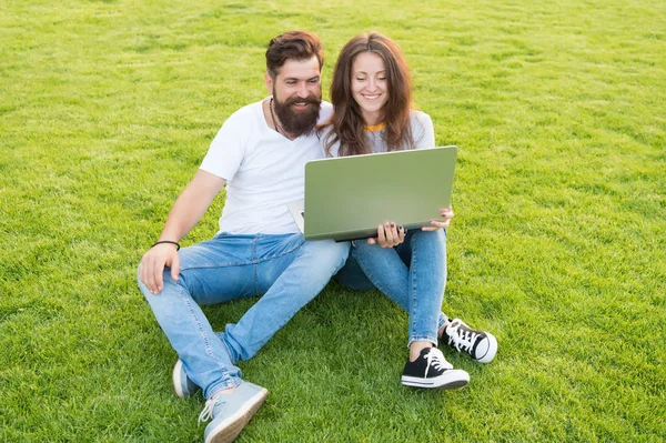 Bilgiye doğru. Parkta bilgisayarla çalışıyor. Adam ve kadın internette defter üzerinde sörf yapıyor. Öğrenci hayatı. İnternetten alışveriş. İletişim devrede. Mutlu çift yeşil çimlerde dizüstü bilgisayar kullanıyor. — Stok fotoğraf