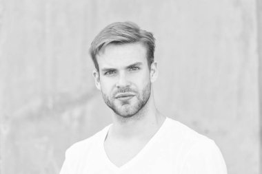 Kendini sev. Erkek çekiciliğinin portresi. Genç, seksi, gri arka plan. Tıraşsız maço adam. Yaz erkek modası. Öğrenci traşsız, stil sahibi saç stili. Sakallı adam, sıradan bir tarz.