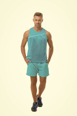 Atletik vücut. Erkek spor kıyafeti. Moda konsepti. Erkek manken mağazası. Spor tarzı. Erkek giyim ve şık kıyafetler. Erkek sporcu beyaz arka planı izole etmiş. Gömlek ve şort giyen yakışıklı bir adam.