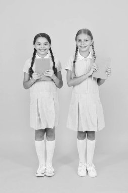 Okullar için eğitim kitapları. Kitap okuyorum. Okul kütüphanesi. Evde eğitim konsepti. Okuryazarlık kulübü. Sarı arka plan üzerine kitaplar tutan sevimli çocuklar. Ansiklopedi veya çocuk kitapları ile küçük kızlar