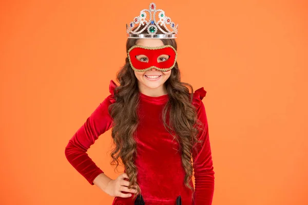 Success is state of mind. Happy girl enjoy success orange background. Little child being excited about success. Small kid wear carnival mask. Crown of success. Successful and proud