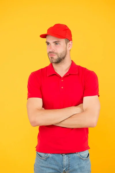Friendly shop assistant. food order deliveryman. cashier vacancy. Fast and free parcel delivery. dealer yellow wall. Salesman cashier career. man delivery service in red tshirt and cap — ストック写真