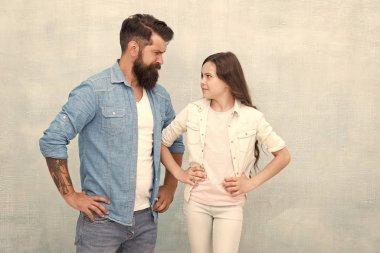 Kız kuralları. Yaramaz kız kötü davranıyor. Gri arka planda babası olan küçük kız çocuk. Sevimli küçük kız ve sakallı adam kalça ellerini koyarak