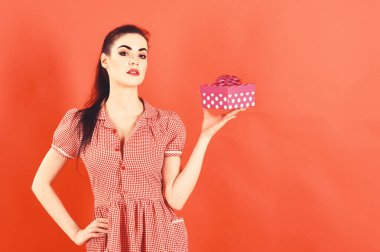 Hediye kutusu kırmızı arka plan ile tutarak çekici neşeli kız portresi.