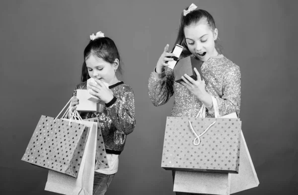 買い物の日。キッズファッション。女の子の姉妹は、ショッピングバッグ青い背景を持つ友人。すべての製品があなたに配信されます。買い物と購入。ブラックフライデー販売と割引。子供の束のパッケージ — ストック写真