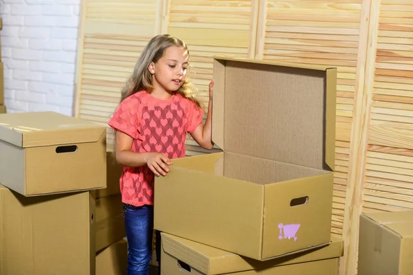 행복 한 어린 소녀. 새로운 거 주지를 매입하는 것. 행복 한 어린이판지 상자. 이동 개념. 새 아파트에 요. 카드 보드 박스 - 새 집으로 이사. 교묘하게 값을 매긴다 — 스톡 사진