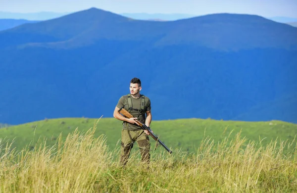 soldier in the field. polygon. army forces. sniper reach target mountain. military style. male in camouflage. man ready to fire. Defence Service. muscular man hold weapon. purpose and success