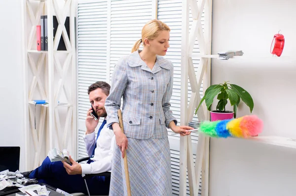 Personal assistant. Equal rights for education work and salary. Gender discrimination in business life. Woman cleaning up office while boss has phone conversation. Gender concept. Gender and career — Stock Photo, Image