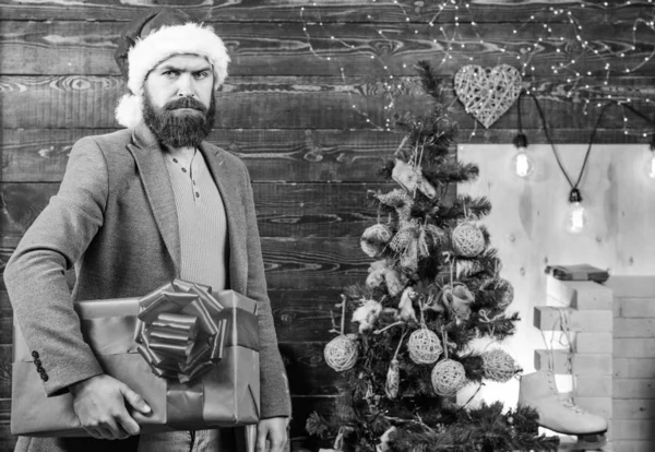 ギフト配達。男サンタ帽子は、ギフトをお届け。広がる幸福感と喜び。ひげを生やした男の真剣な顔は、プレゼント ボックスを運ぶ。配信クリスマス プレゼント。配信サービス。クリスマスが来ています。サンタの宅配便 — ストック写真