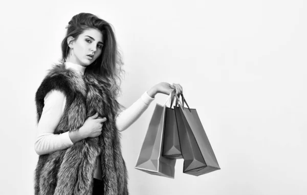 Verkoop- en korting op black friday. Fashionista kopen kleding in de winkel. Meisje make-up gezicht wear fur vest witte achtergrond. Vrouw winkelen luxe boutique. Dame houd boodschappentassen. Winkelen op concept — Stockfoto