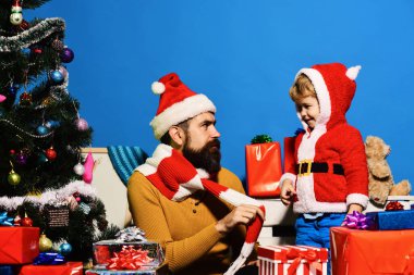 Sakallı ve ciddi yüzlü bir adam oğluyla oynuyor..