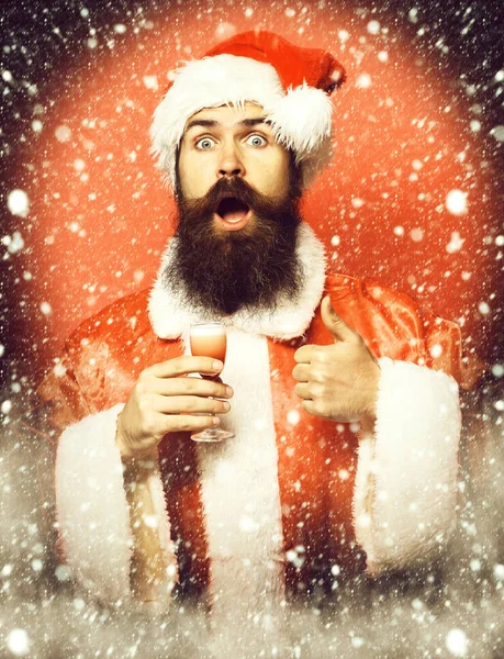 Handsome bearded santa claus man with long beard on surprisedface holding glass — 스톡 사진