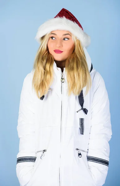Mikulás lány. A lány fehér kabátot és télapó sapkát visel. A kabát extra szigeteléssel rendelkezik, és kissé hosszabb ideig alkalmas arra, hogy megvédje a testét az éles téli időjárástól. Fehér dzseki. Várakozó fagyos karácsonyi napok — Stock Fotó