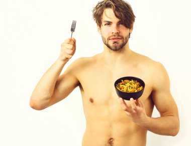 Kafkas seksi genç maço elinde makarna ile siyah kase tutuyor.