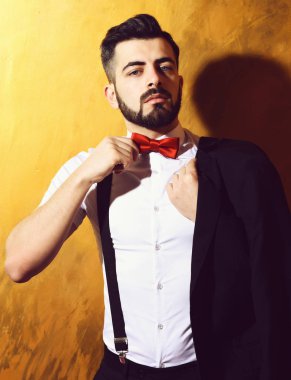 Stüdyo duvarında ciddi bir yüzü olan sakallı bir adam.