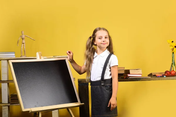 Kid e material escolar no fundo da parede amarela — Fotografia de Stock