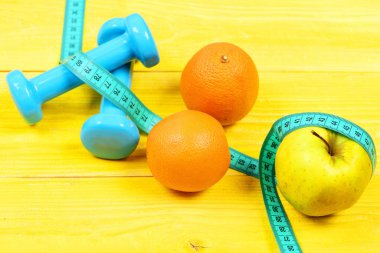 egzersiz kavramı, dumbell ağırlık ölçüm bandı, portakal ve elma ile