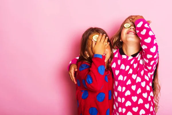 Dívky v barevné polky tečkovaný pyžama obejmout a zavřete oči — Stock fotografie