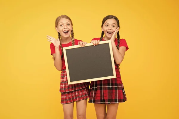 Wat een goed nieuws. kinderen die prikbord presenteren. grote verkoop. gelukkige kleine meisjes met Blackboard. plaats vooraankondiging. informatie kantoor. presentatie van het school project. ruimte kopiëren — Stockfoto