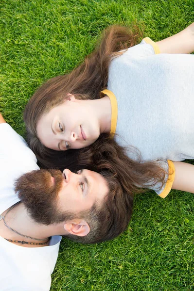 Dating concept. bearded hipster and girl carefree. Youth and freedom. Closer to nature. couple feel free. couple lie on green grass. man and woman relax outdoor. dreaming concept. Spring time — 스톡 사진