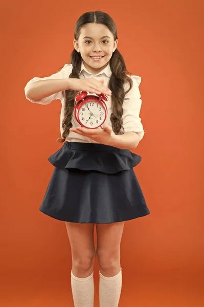 Classes begin. Developing discipline. Time for break and relax. Vacation time. Elementary school day bell schedule. Schooltime concept. Schoolgirl child formal uniform hold alarm clock. Time to study — Stock Photo, Image