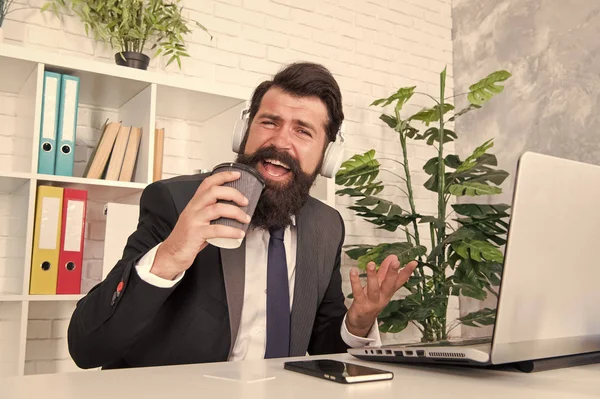 Regelmäßiger Morgen im Amt. Motivationsmusik. Viel Spaß. Gesangliches Hobby. Konzept der Stressresistenz. Manager entspannen bei Lieblingsmusik und Tasse Kaffee. Mann Büroangestellte hört Musik-Kopfhörer — Stockfoto