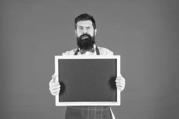 Hora do jantar. Empregado brutal na cozinha. homem maduro pano de fundo vermelho. Barman hipster assustado. O que cozinhar. Menu de restaurante. anúncio de loja de café. Homem barbudo chalkboard, espaço de cópia. Não gosto disso. — Fotografia de Stock