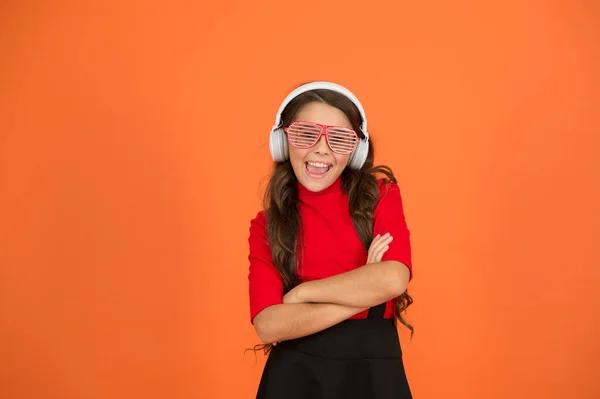 Um acessório de festa. Menina com óculos fundo laranja. Evento e entretenimento. Rapariga da festa. A divertir-me. Lista de jogos para a festa. Conceito musical. O miúdo usa óculos. Loja de moda de óculos. Faixa fria — Fotografia de Stock