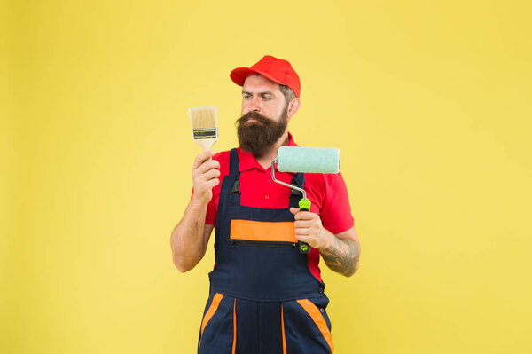 Construction worker ready to work. brutal hipster try to be craftsman. professional repairer. serious builder man. bearded worker. Hard worker with painting brush and roller