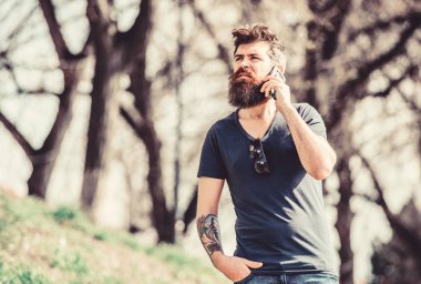 Cep telefonlu acımasız bir işadamı. Konuşma ve tartışma. Sakallı adam cep telefonundan konuşuyor. Sakallı, olgun bir hippi. İş konuşması. Hipster adam akıllı telefonu tutar. çevik iş