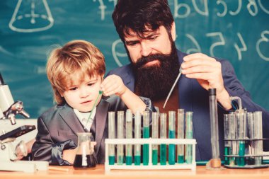 Baba ve oğul okulda. Biyoteknoloji araştırma konsepti. Okula dönelim. Biyolojiyi çocuğa açıklamak. Sakallı öğretmen ve küçük çocuk. Kimya ve fizik biyolojisi. Kimyasal madde alalım.
