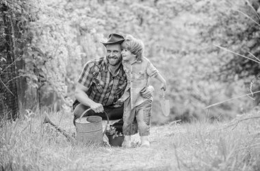 Babam küçük oğul bakım bitkileri öğretiyor. Bahçede küçük bir yardımcı. Çiçek dikiyorum. Büyüyen bitkiler. Taze fide. Bitkilere iyi bak. Çocuk ve baba doğada sulama yapabilir. Bahar bahçesi