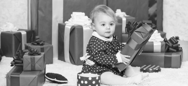 Маленький ребенок играет рядом с кучей упакованных красных подарочных коробок. Подарки для первого ребенка. Моё первое Рождество. Делиться радостью первого Рождества с семьей. Детское первое Рождество раз в жизни — стоковое фото