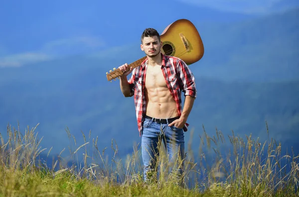 Man med gitarr går på toppen av berget. Bästa sättet att fly från staden. Guy vandrare njuta av ren natur. Utforskar naturen. Naturens skönhet. Frisk bergsluft. Semestermål. Att gå ensam — Stockfoto