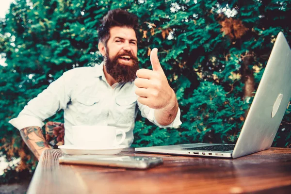 Bearded man successful freelance worker. Remote job. Freelance professional occupation. Good job expression. Well done. Hipster busy with freelance. Wifi and laptop. Drink coffee and work faster