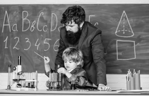 Maestro barbudo con niño pequeño. padre e hijo en la escuela. Alumno en el carisma de confianza de la clase de química. De vuelta a la escuela. Concepto de química científica. Centrado en el examen — Foto de Stock