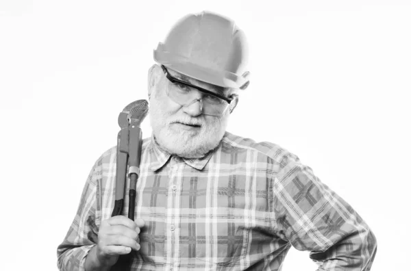 Carry out repairs. man builder with adjustable pipe wrench. professional repairman in helmet with gas wrench. architect repair and fix. engineer worker. build and construction. mature bearded man. — Stock Photo, Image