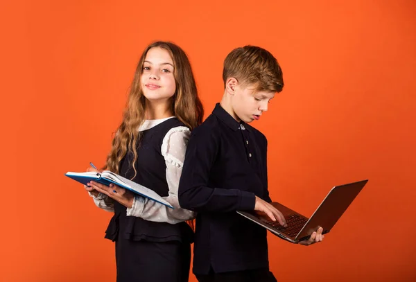 Crea futuro. Los niños pequeños usan el libro de TI y la computadora. Niña y niño estudian en la escuela. Educación en línea. Educar a las generaciones futuras. Hoy en día los niños, mañana el futuro. El futuro es ahora — Foto de Stock