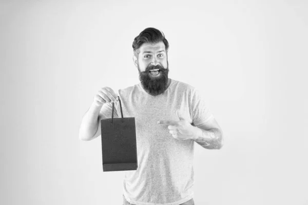 Buy product. Gender differences in purchase decision making. Happy hipster hold paper bag. Bearded man smiling with fashion purchase. Impulse purchase. Shopping concept. Shop store mall boutique