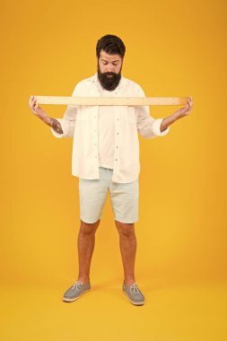 Bir metre. Büyük beden. Ölçü. Geometri teoremi. Gerçek boyut. Okul öğretmeni. Küçük, büyük, iri. Boyut gerçekten önemli mi? Adam sakallı hipster cetvel tutan. Uzunluğu ölçün. Boyut uzun ve uzunluk