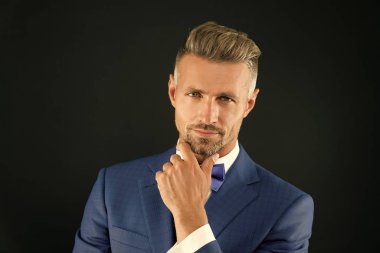 Aklında bir şey var. Centilmen hippi saç modeli. Berber dükkanı konsepti. Sakal ve bıyık. Yakışıklı, maço bir düğün smokinini iyi giydirmiş. Hippi damat. Kurnaz bir bakış. Çekici olgun hippi.