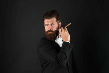 Sadece erkekler için berber dükkanı. İş adamının elinde berber aleti var. Geçmişi karanlık. Berber dükkanında sakallı adam tıraş olur. Berber dükkanı konsepti. Tıraş ve saç kesimi. Berber dükkanı. Berber dükkanı tarzı burada başlıyor.