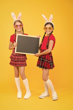 Paskalya yaklaşıyor. Mutlu Paskalyalar. Tavşan kulaklı, tahtası olan küçük kızlar. duyuru için yer. Okul projesi sunumu. kopyalama alanı. Çocukların elinde tebeşir tahtası var. Büyük satışlar. Paskalya partisi