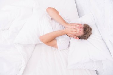 Uyumak istiyorum. Sabah erken kalktım. Uyku bozuklukları konsepti. Adamın uyku sorunları var. Beyaz yatak odasında yatan bir adam. Rahatlama zamanı. Sabah seksi konsepti. Erkek sağlığı konsepti. Yorgun adam yatakta uyuyor.