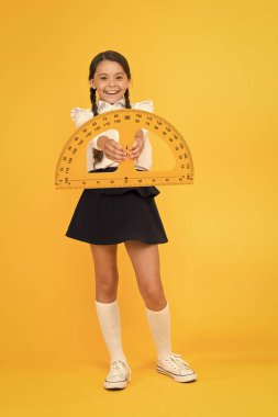 çok çalış. öğrenci kullanımı protractor cetvel. kök sınıf. Matematik bilimi. Okula geri dön. Matematik eğitimi. Sarı arka planda üniformalı çocuk. mutlu küçük okul kız çalışma geometri