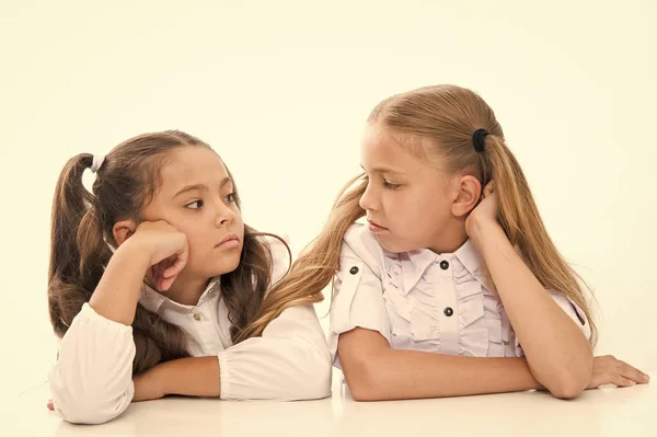 Schattig schoolmeisjes. Formele stijl. Gelukkige kindertijd. Schoolmeisjes zitten op Bureau witte achtergrond. Schoolmeisjes emotionele vrienden. Terug naar school. Onderwijsconcept. Mooie meiden beste vrienden — Stockfoto