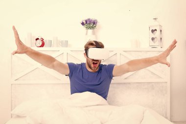 Geleceğe adım atmak. Yatakta sanal gerçeklik kulaklığı takan yakışıklı bir adam. Gelecek vizyonu. Eğlencenin ve iletişimin geleceği. Gelecek konsepti