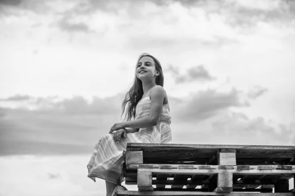 Enfant heureuse petite fille. Gratuit et insouciant. Concept d'innocence. Joyeuse journée internationale de l'enfance. Bonne enfance. Jolie petite fille robe d'été en plein air ciel fond. Joyeuses vacances. Profiter de détente — Photo